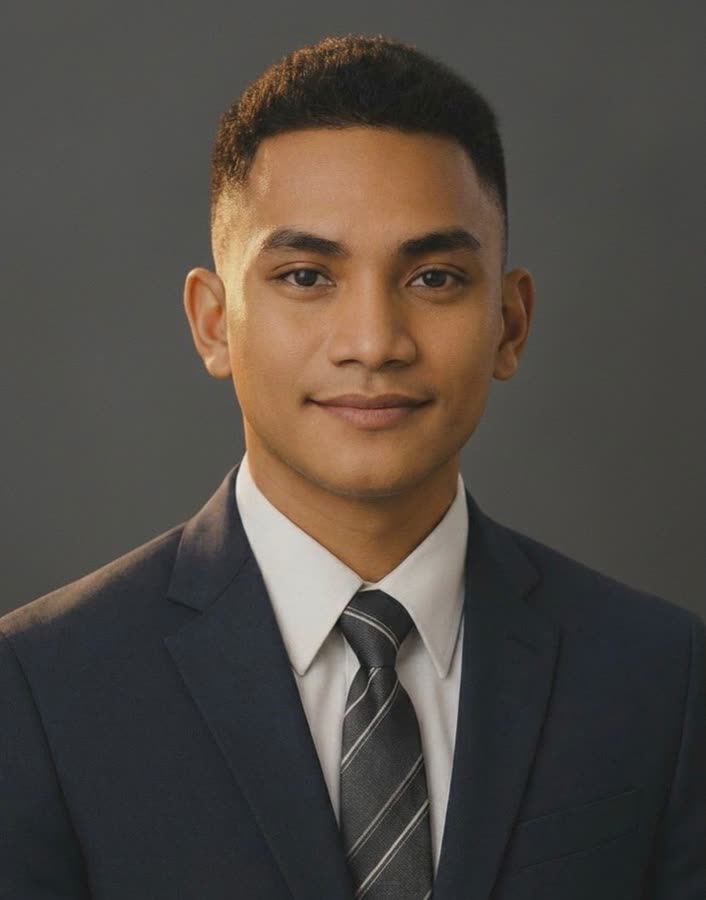 Gerald Donato, in a dark suit and striped tie, against a grey background.