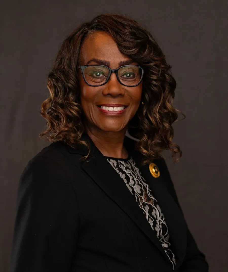 Dianne L Oliphant, smiling, in a light blazer against a plain background.